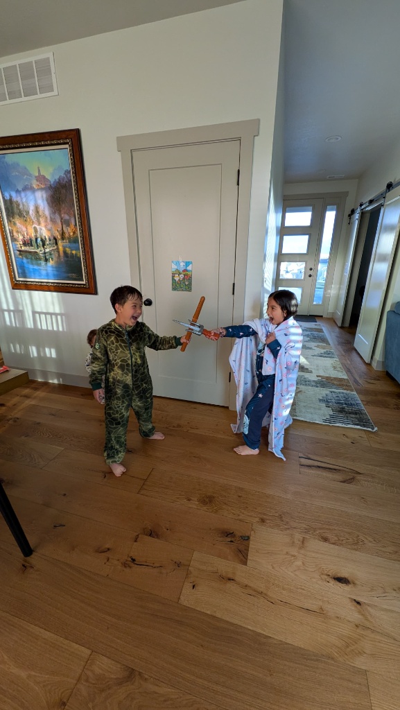 Real photo of two kids playing with toy swords